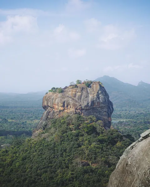 Sigiriya rock fortress rising above a sea of green treetops