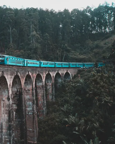 Blue train crossing the Nine Arches Bridge near Ella